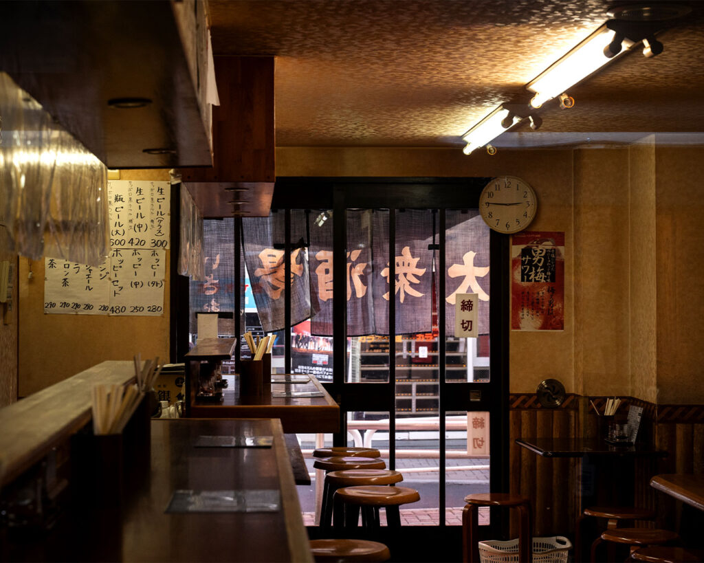 An intimate private izakaya dining space featuring traditional Japanese wooden interiors, soft ambient lighting, and a calm, exclusive setting designed for small group gatherings.
