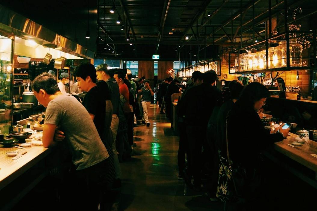 A group of people enjoying their meal in the evening hours of a Singapore restaurant serving Japanese delicacies.