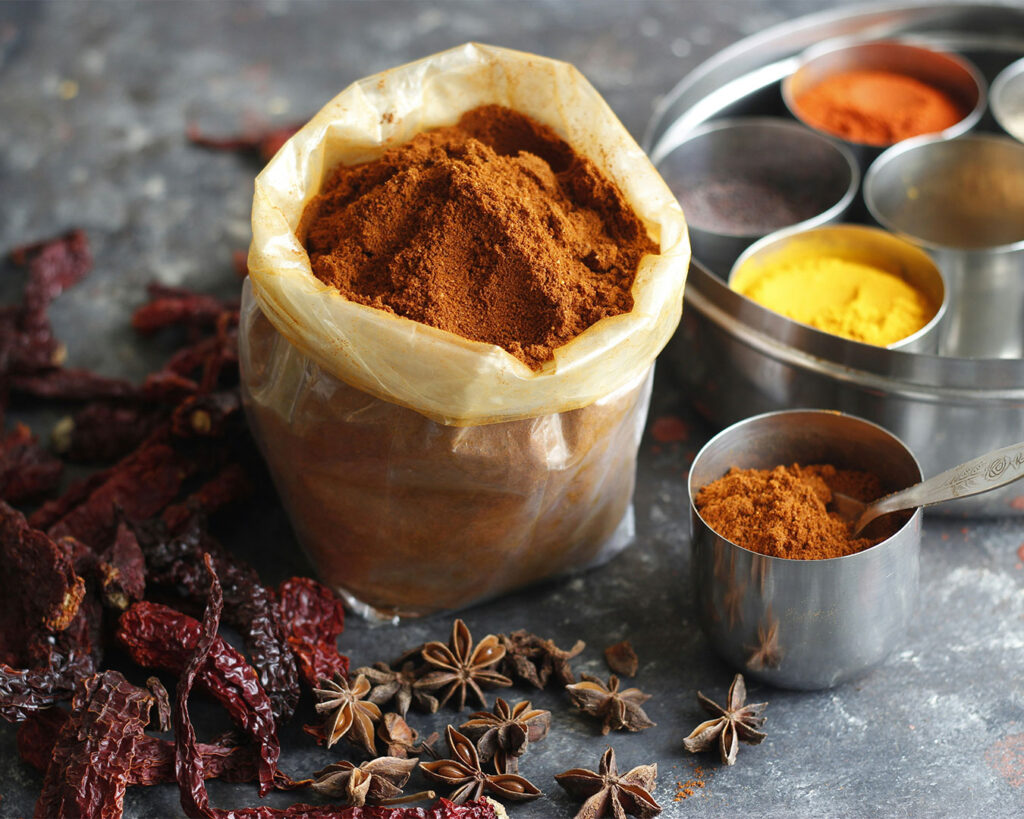 Bright yellow curry powder in a bowl, showing its fine texture and bold, spicy tone.