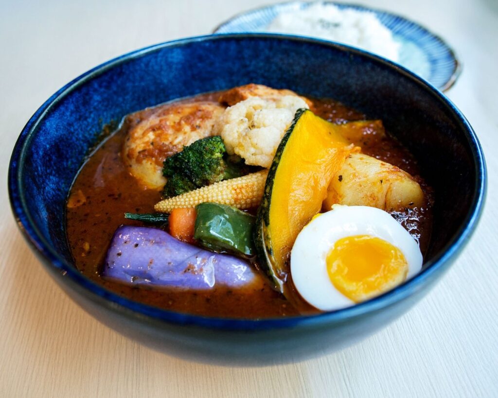 Traditional Japanese soup curry served with vibrant vegetables and tender protein, highlighting deep flavours and balanced spices.