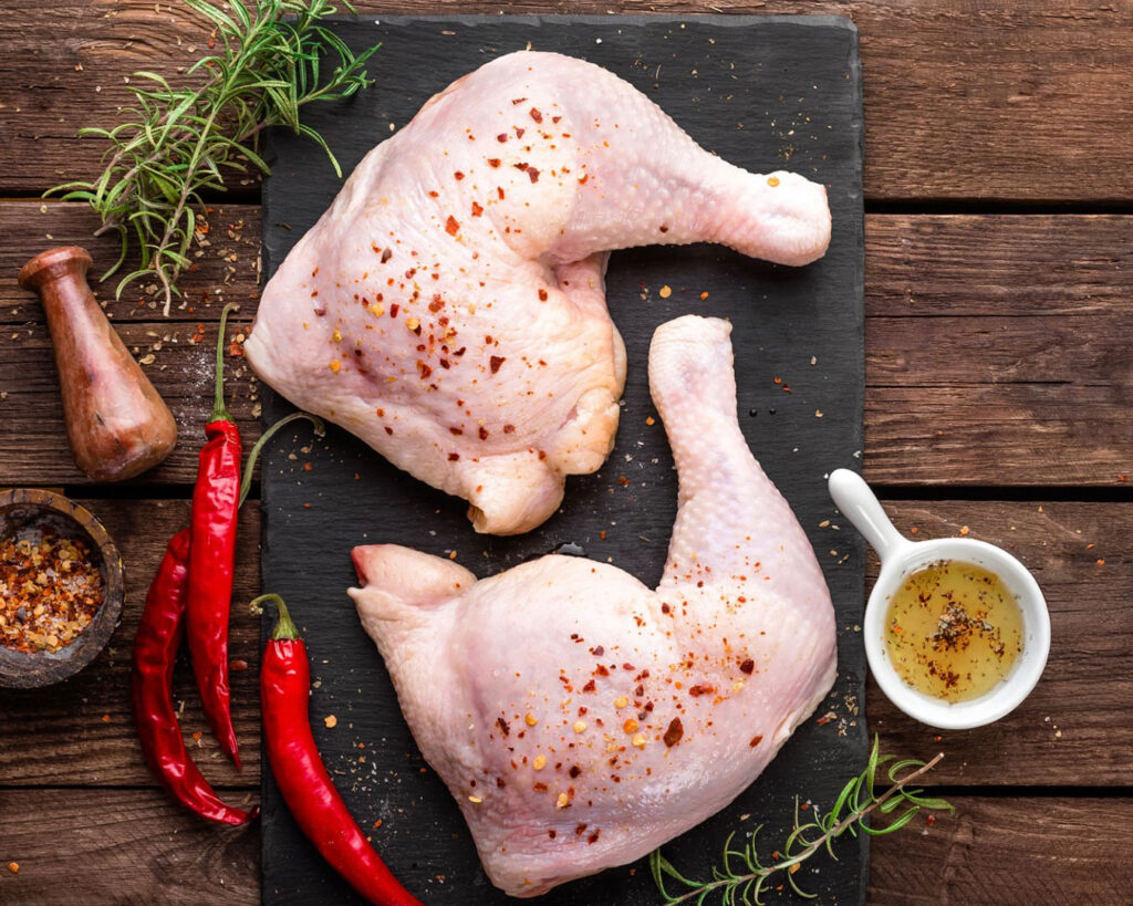Raw chicken thigh placed on a preparation table, showing its natural texture before cooking.