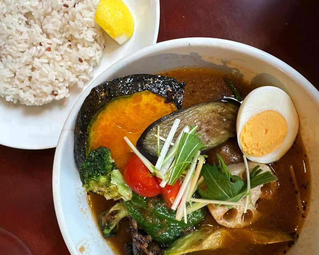 Soup curry and rice served separately, allowing diners to mix flavours according to their preference.