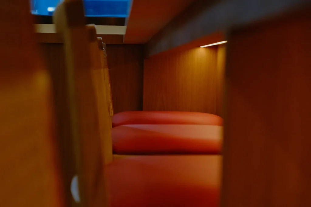 A close-up view of red cushions positioned against wooden furniture, creating a cozy interior ambiance.