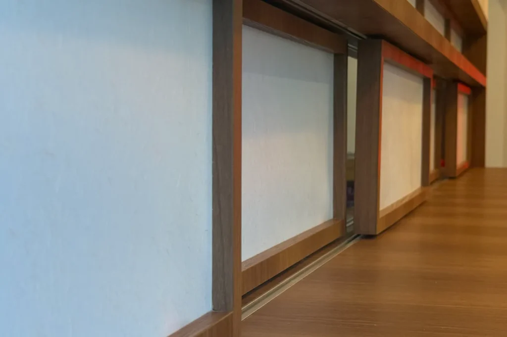 Close-up of a Japanese shoji screen with wooden frames and white paper panels, creating a serene and minimalist atmosphere. Horizontal pattern emphasized.