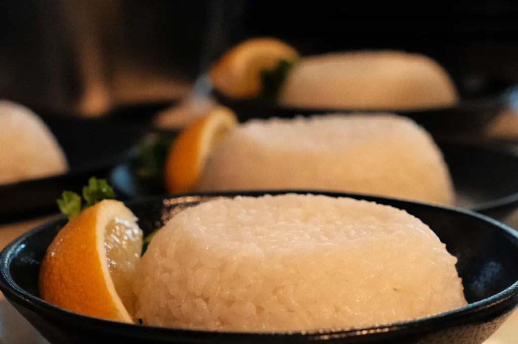 A close-up of a plate of rice garnished with lemon slices and parsley.