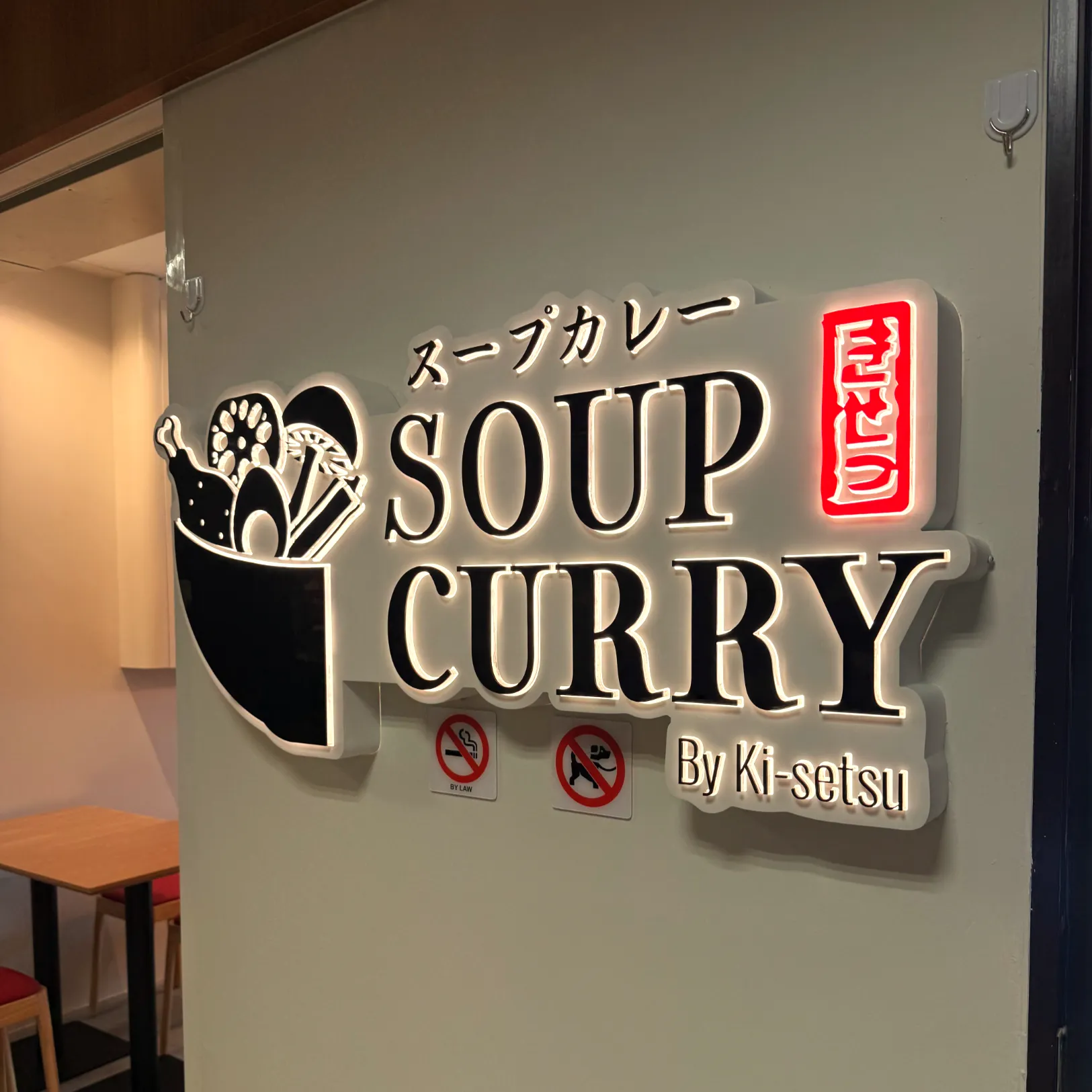 A sign for a restaurant that reads "SOUP CURRY" in both English and Japanese, with the name "By Ki-setsu" below it.